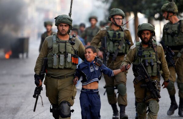 جنود إسرائيليون يعتقلون طفلا فلسطينيا خلال اشتباكات في الخليل، الضفة الغربية، 13 أكتوبر/ تشرين الأول 2017 - سبوتنيك عربي
