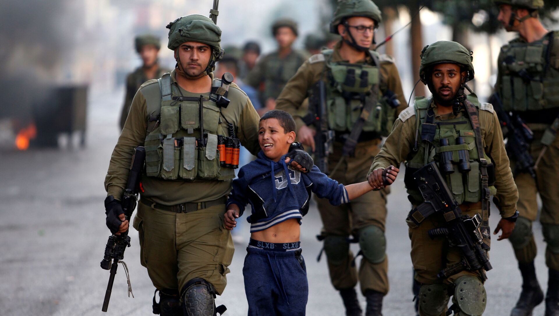 جنود إسرائيليون يعتقلون طفلا فلسطينيا خلال اشتباكات في الخليل، الضفة الغربية، 13 أكتوبر/ تشرين الأول 2017 - سبوتنيك عربي, 1920, 20.06.2021