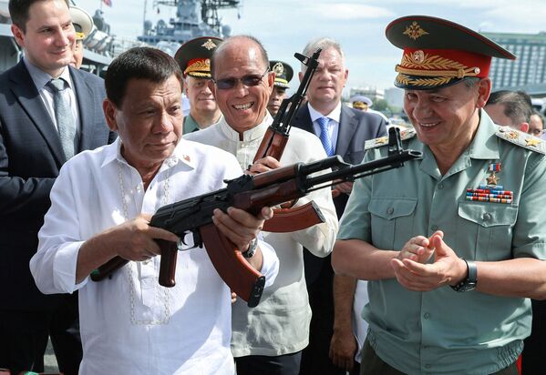 الرئيس الفلبيني رودريغو دوتيرتي ووزير الدفاع الروسية سيرغي شويغو يتفقدان بندقية  AK-47  في ميناء مانيلا، الفلبين 25 أكتوبر/ تشرين الأول 2017 - سبوتنيك عربي