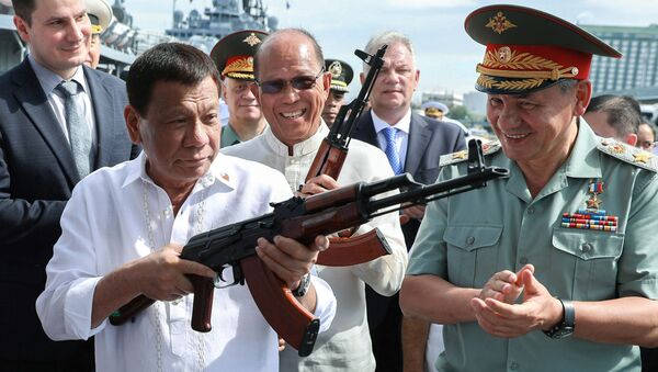 الرئيس الفلبيني رودريغو دوتيرتي ووزير الدفاع الروسية سيرغي شويغو يتفقدان بندقية  AK-47  في ميناء مانيلا، الفلبين 25 أكتوبر/ تشرين الأول 2017 - سبوتنيك عربي