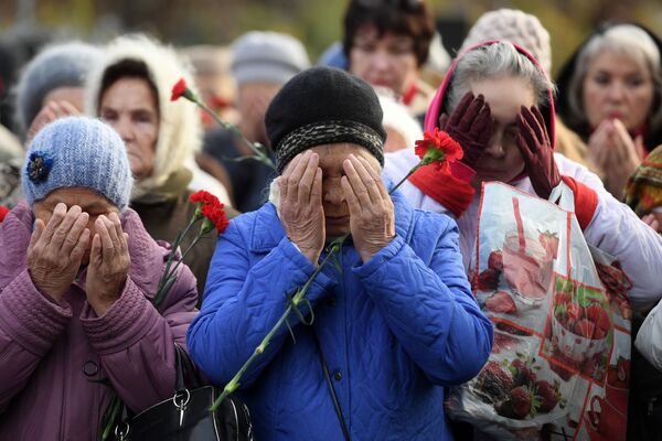 سكان قازان يقفون أمام نصب تذكاري بمقبرة أرسكوي لإحياء ذكرى ضحايا عمليات القمع السياسي في القرن الماضي - سبوتنيك عربي