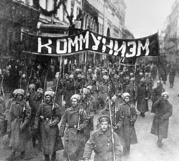 ثورة أكتوبر عام 1917 - مجموعات من الجنود الثوريين يحملون شعار كومونيزيم (الشيوعية) يسيرون في شارع نيكولسكايا في موسكو، عام 1917 - سبوتنيك عربي