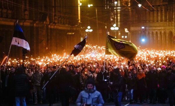 مواطنون يحملون الشعلة النارية خلال مسيرة بمناسبة يوم الاستقلال في ريغا، لاتفيا - سبوتنيك عربي