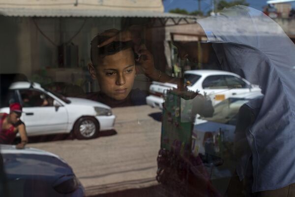 صبي، 14 عاما، في محل للحلاقة قبل بدء الانتخابات العامة في هندوراس، والتي ستعقد في 26 نوفمبر/ تشرين الثاني 2017 - سبوتنيك عربي