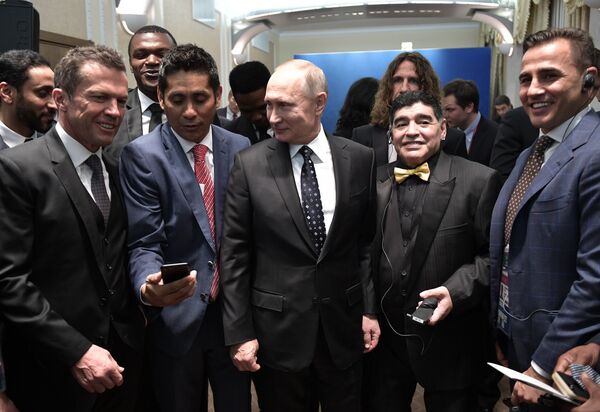 الرئيس الروسي فلاديمير بوتين مع نجوم الكرة العالمية، من اليمين  الإيطالي فابيو كانافارو، الأرجنتيني دييغو مارادونا، الألماني لوثر ماتيوس - سبوتنيك عربي