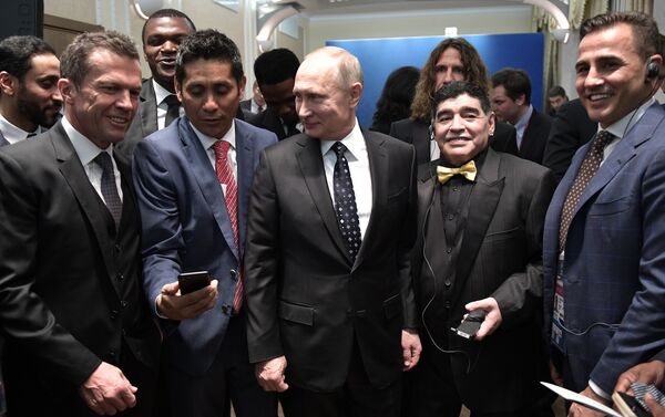 الرئيس الروسي فلاديمير بوتين مع نجوم الكرة العالمية، من اليمين الى اليسار، الإيطالي فابيو كانافارو ، الأرجنتيني ديغو مارادونا، الألماني لوثر ماتيوس - سبوتنيك عربي