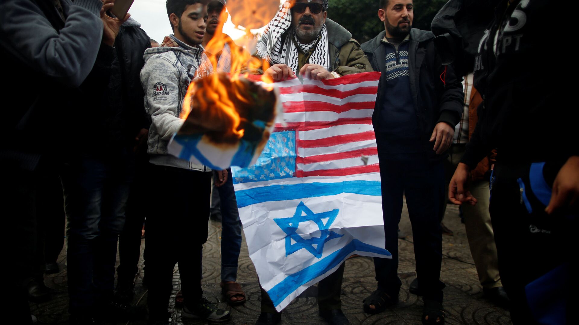  فلسطينيون يحرقون العلمين الأمريكي والإسرائيلي في مدينة غزة، قطاع غزة، فلسطين 6 ديسمبر/ كانون الأول 2017 - سبوتنيك عربي, 1920, 14.01.2022