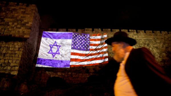 رجل يسير علعى خلفية إنعكاس العلمين الإسرائيلي والأمريكي على سور بمدينة القدس القديمة، 6 ديسمبر/ كانون الأول 2017 - سبوتنيك عربي