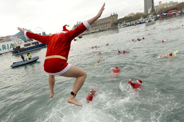 مشارك في زي سانتا كلاوز يقفز إلى مياه ميناء برشلونة، ضمن مسابقة كوبا نادال (كأس الميلاد) في إسبانيا، 25 ديسمبر/ كانون الأول 2017 - سبوتنيك عربي