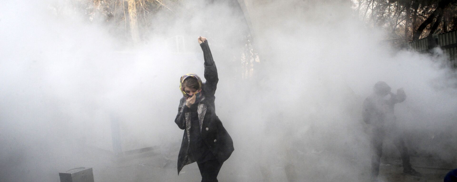 طالبة جامعية في مظاهرة داخل جامعة طهران وقت إلقاء قنبلة دخان من قبل الشرطة الإيرانية لمكافحة الشغب - سبوتنيك عربي, 1920, 18.12.2018
