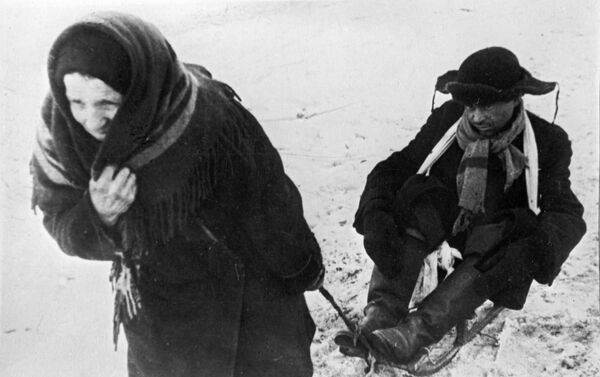 امرأة تجر زوجها الذي أصبح هزيلا جراء مجاعة لينينغراد، خلال حصار المدينة - سبوتنيك عربي