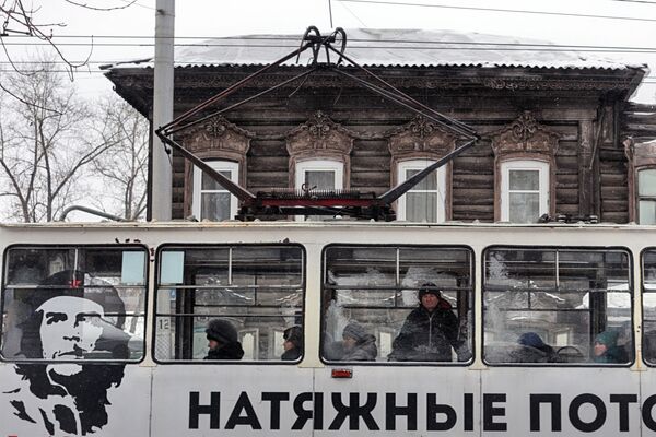 حافلة عليها إعلان على خلفية منزل قديم في إركوتسك - سبوتنيك عربي