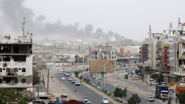 الدخان يتصاعد من مخزن قطع غيار السيارات أصيب بقذائف خلال الصراع في مدينة عدن الساحلية - سبوتنيك عربي