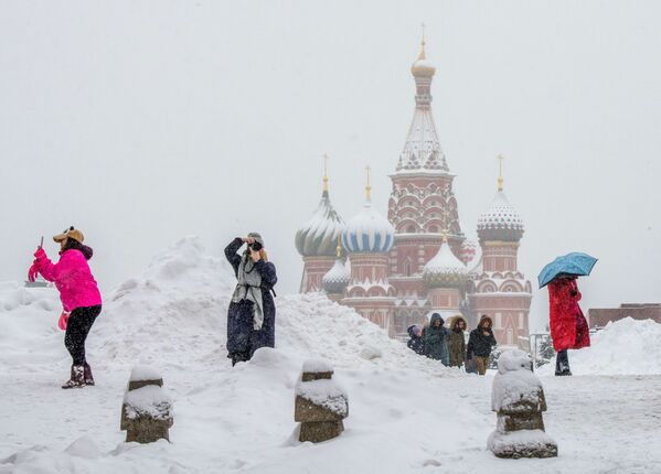 سياح يلتقطون صورا على الساحة الحمراء خلال تساقط اللثوج الكثيفة في موسكو، روسيا 31 يناير/ كانون الثاني 2018 - سبوتنيك عربي