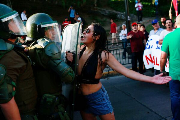 متظاهرة تصرخ على شرطي خلال مظاهرة في سانتياغو، تشيلي 29 يناير/ كانون الثاني 2018 - سبوتنيك عربي
