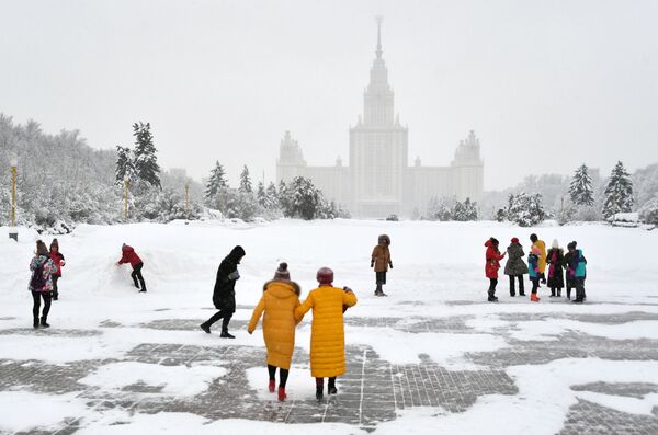 السياح على ممشى العلماء بالقرب من منصفة المشاهدة على تل فوروبيوفي غوري (تل الدويري) خلال تساقط الثلوج في موسكو - سبوتنيك عربي