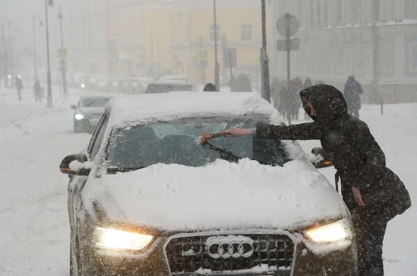 املاأة تنظف سيارتها من الثلج والجليد في موسكو - سبوتنيك عربي