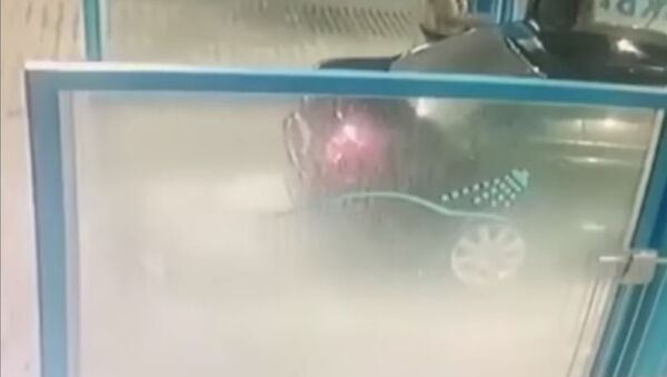 رجل يرش إمرأة في مغسل للسيارات - سبوتنيك عربي