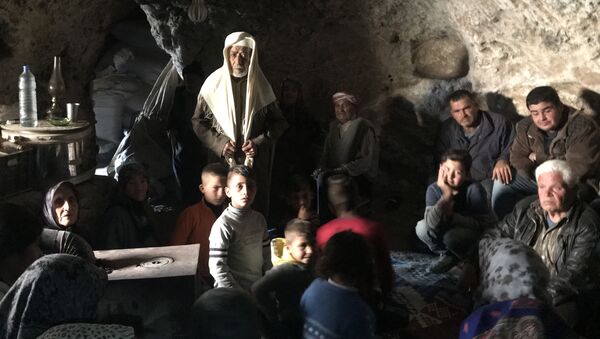 لاجئون كرديون يختبئون من الضربات الجوية التركية في منطقة جبلية في ضواحي عفرين شمال سوريا - سبوتنيك عربي
