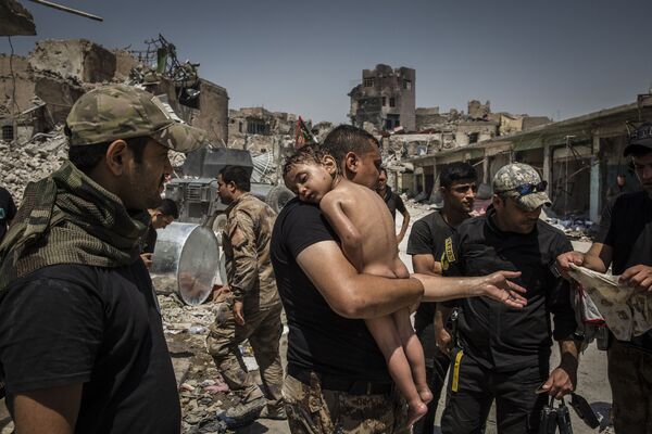 مسابقة صور الصحافة العالمية لعام 2018 - صورة بعنوان معركة تحرير الموصل - أفراد القوات الخاصة العراقية يعتنون بصبي للمصور إيفور بريكيت، في فئة التصوير صور الصحافة العالمية لهذا العام - سبوتنيك عربي