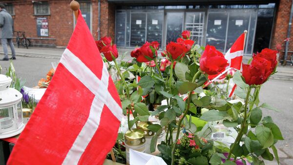 A Danish flag and roses are placed in front of a cultural club in Copenhagen, Denmark, Tuesday, Feb. 17, 2015. - سبوتنيك عربي