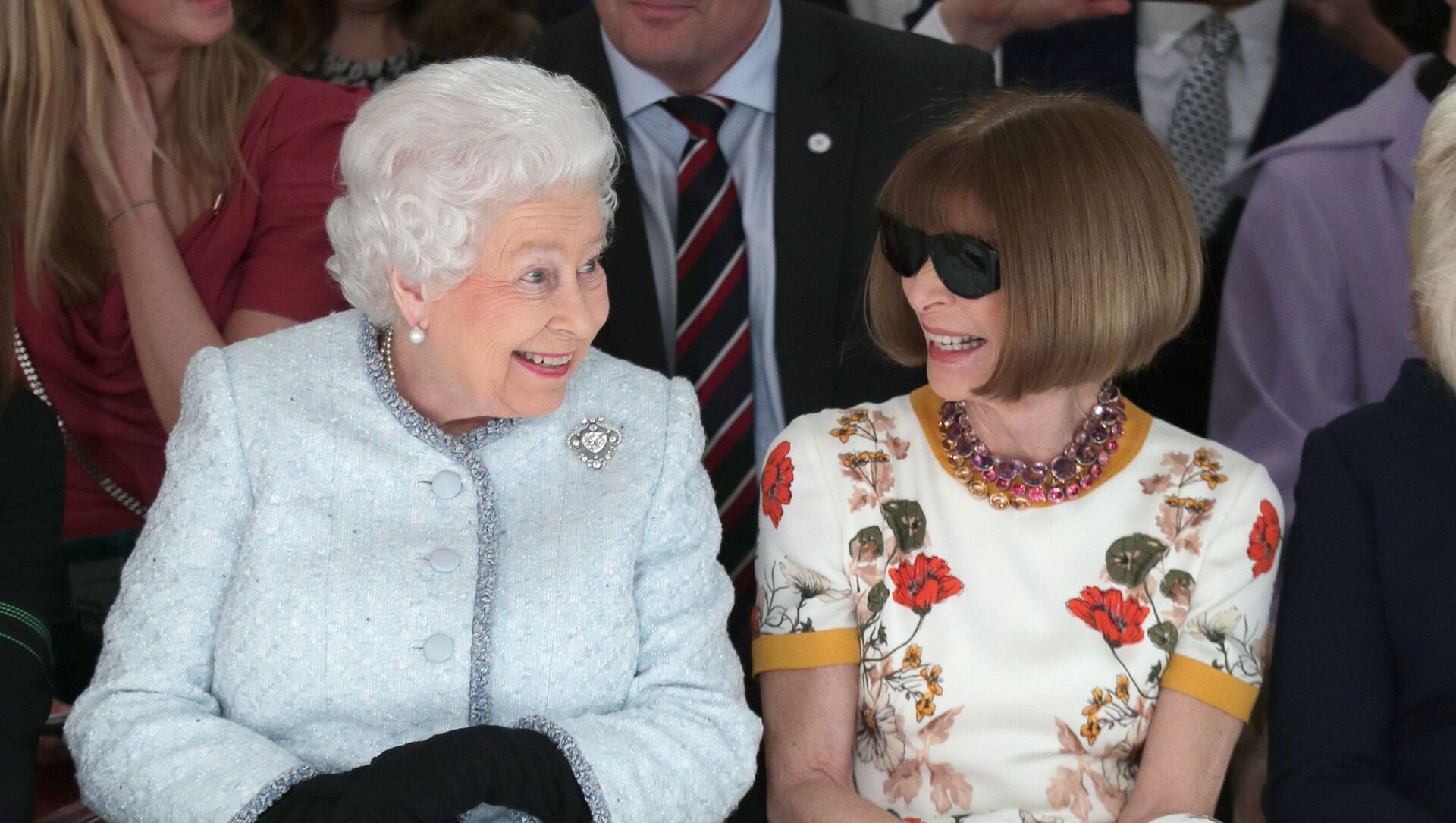 ملكة بريطانيا إليزابيث الثانية تجلس مع رئيس تحرير مجلة فوغ في عرض أزياء أقيم في العاصمة البريطانية لندن في 20 فبراير/شباط 2018 - سبوتنيك عربي, 1920, 19.10.2021