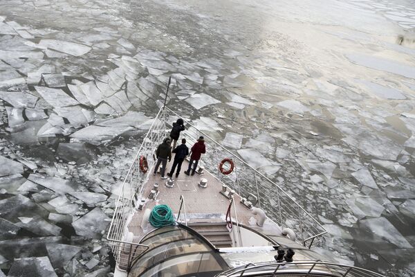 ركاب يقفون على متن زورق سياحي في نهر موسكو المغطى بالجليد، موسكو، 26 فبراير/ شباط 2018 - سبوتنيك عربي