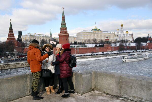 مواطنون على جسر بولشوي كاميني يلتقطون صورة سيلفي على خلفية نهر موسكو المغطى بالجليد - سبوتنيك عربي