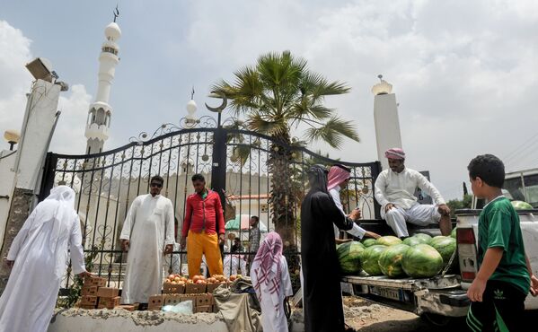 رجال يتبضعون في كشك للفواكه خارج مسجد في مدينة الطائف، السعودية في 28 يوليو/ تموز 2017 - سبوتنيك عربي