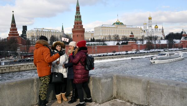 مارة يلتقطون صورا على خلفية الكرملين في موسكو - سبوتنيك عربي