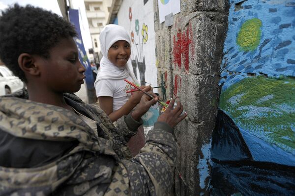 أطفال يمنيون يرسمون لوحة غرافيتي على الجدران لدعم السلام، في إطار حملة يوم مفتوح للفن في العصامة صنعاء، اليمن 15 مارس/ آذار 2018 - سبوتنيك عربي