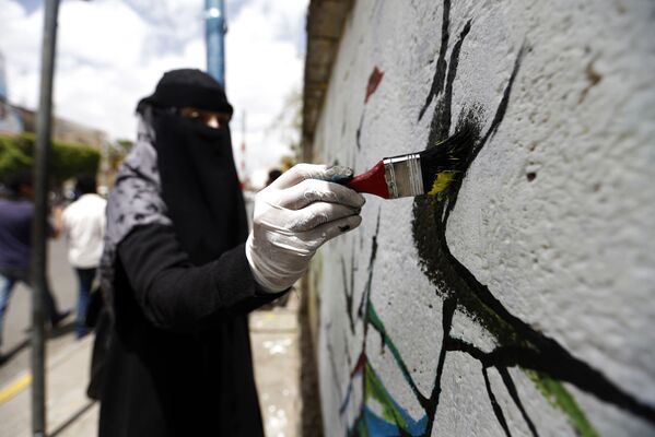 فنانة يمنية ترسم لوحة غرافيتي على الجدران لدعم السلام، في إطار حملة يوم مفتوح للفن في العصامة صنعاء، اليمن 15 مارس/ آذار 2018 - سبوتنيك عربي