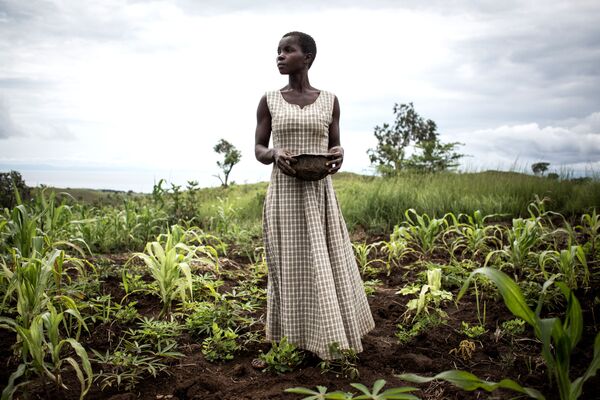 امرأة تزرع بذور في محيط معسكر مؤقت للمشردين داخل المنطقة والعائدين، جمهورية الكونغو الديمقراطية، 21 مارس/ أذار 2018 - سبوتنيك عربي