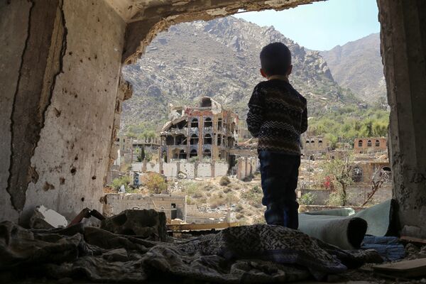 صبي صغير يقف على خلفية ركام في تعز، اليمن 18 مارس/ آذار 2018 - سبوتنيك عربي