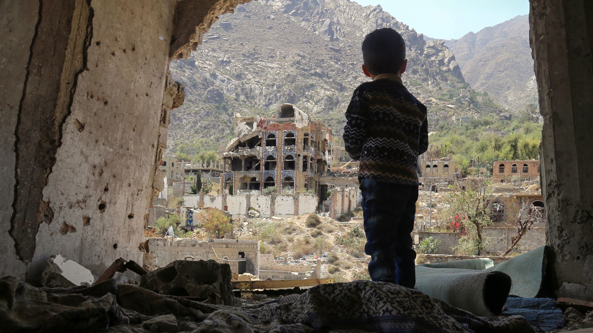 صبي صغير يقف على خلفية ركام في تعز، اليمن 18 مارس/ آذار 2018 - سبوتنيك عربي, 1920, 23.05.2022