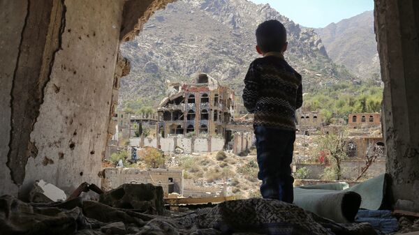 صبي صغير يقف على خلفية ركام في تعز، اليمن 18 مارس/ آذار 2018 - سبوتنيك عربي