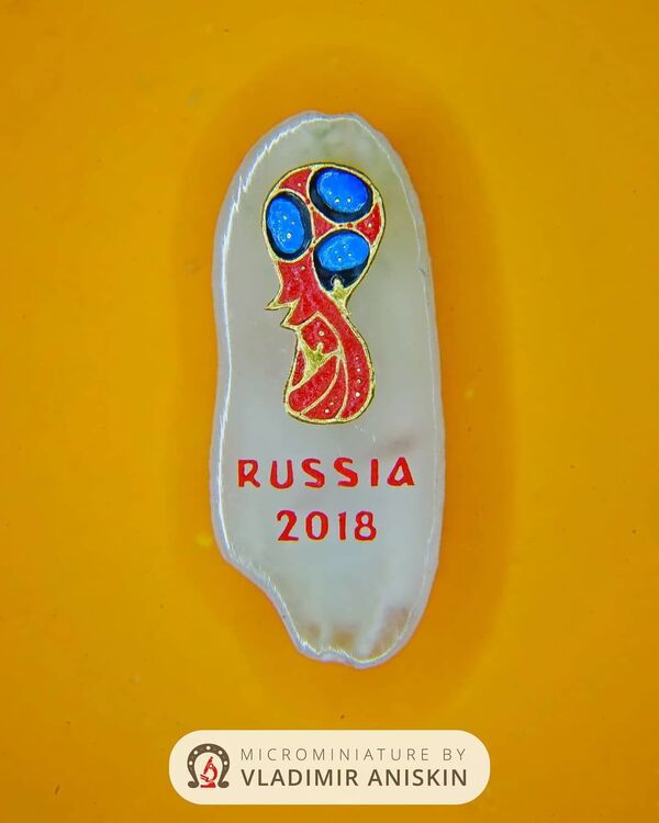 شعار كأس العالم بكرة القدم 2018 على حبة الأرز لرسام الفن الدقيق الروسي فلاديمير أنيسكين - سبوتنيك عربي