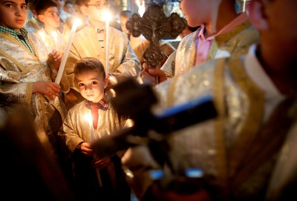 الأطفال الفلسطينيون يحتفلون بعيد الفصح في كنيسة القديس بورفيريوس بمدينة غزة، قطاع غزة، فلسطين 1 أبريل/ نيسان 2018 - سبوتنيك عربي
