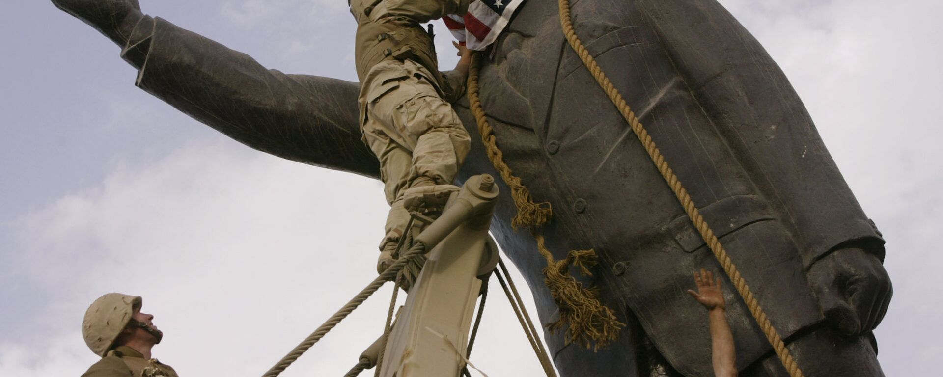 مجند أمريكي يضع علم الولايات المتحدة على رأس تمثال صدام حسين في عام 2003 في بغداد - سبوتنيك عربي, 1920, 05.02.2023