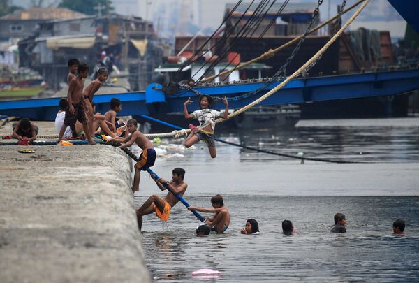 أطفال يقفزون إلى مياه خليج مانيلا هروبا من الحر، الفلبين 11 أبريل/ نيسان 2018 - سبوتنيك عربي