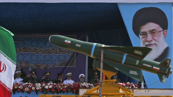 شاحنة عسكرية إيرانية تحمل صواريخ أمام لوحة للزعيم الإيراني الأعلى آية الله علي خامنئي خلال استعراض بمناسبة يوم الجيش السنوي للبلاد، 18 أبريل/نيسان 2018 في طهران. - سبوتنيك عربي