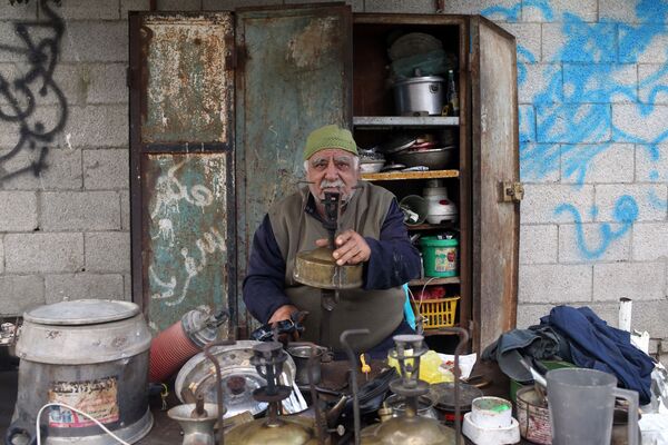 جودت الخور  (75 عاما) - يعمل على تصليح ألواح الكيروسين المستخدمة في الطبخ، مدينة غزة، قطاع غزة، فلسطين 23 أبريل/ نيسان 2018 - سبوتنيك عربي
