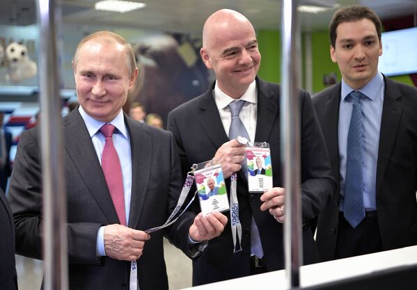 الرئيس الروسي فلاديمير بوتين وجياني إنفانتينو رئيس الاتحاد الدولي لكرة القدم (فيفا) يحصلنان على جواز المشجع في مدينة سوتشي، روسيا 3 مايو/ أيار 2018 - سبوتنيك عربي