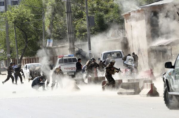 قوات الأمن تركض بعيدا من موقع عملية انتحارية في كابول، أفغانستان 30 أبريل/ نيسان 2018 - سبوتنيك عربي