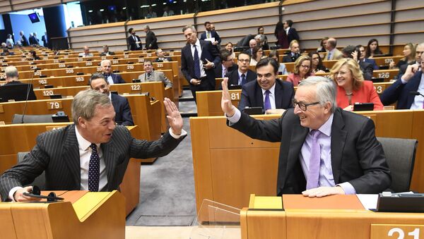 رئيس المفوضية الأوروبية جان كلود يونكر (يمين) وعضو حملة البرلمان الأوروبي نايجل فاراج يتبادلان ضرب الأكف في بداية الجلسة العامة حول ميزانية الاتحاد الأوروبي المقبلة على المدى الطويل في بروكسل، في 2 ماية/ أيار 2018. - سبوتنيك عربي