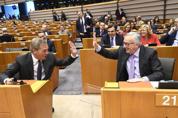 رئيس المفوضية الأوروبية جان كلود يونكر (يمين) وعضو حملة البرلمان الأوروبي نايجل فاراج يتبادلان ضرب الأكف في بداية الجلسة العامة حول ميزانية الاتحاد الأوروبي المقبلة على المدى الطويل في بروكسل، في 2 ماية/ أيار 2018. - سبوتنيك عربي