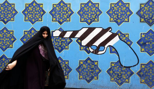 امرأة إيرانية على خلفية رسم غرافيتي على جدار المبنى السابق السفارة الأمريكية في طهران، إيران 8 مايو/ أيار 2018 - سبوتنيك عربي
