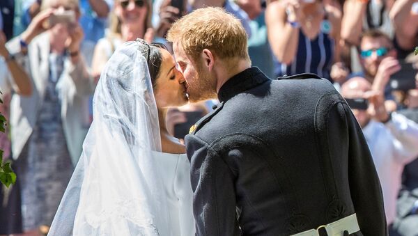نجل ولي عهد بريطانيا الأمير هاري يقبل عروسه ميغان ماركل في حفل زفافهما، 19 مايو/أيار 2018 - سبوتنيك عربي