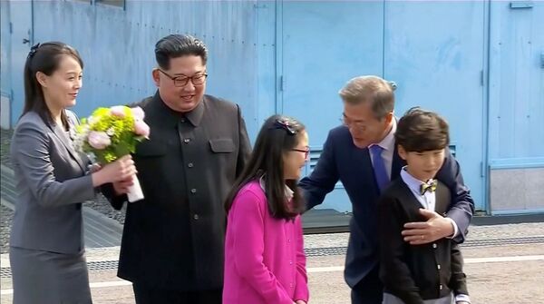 الزعيم الكوري الشمالي كيم جونغ أون وشقيقته كيم يو جونغ إلى جانب الرئيس الكوري الجنوبي مون جاي-إن بعد أن أهدى الأخير باقة من الأزهار لها، وذلك قبل اللتوجه إلى القمة الكورية المشتركة في قرية الهدنة في بانمونجوم، كوريا الجنوبية 27 أبريل/ نيسان 2018 - سبوتنيك عربي