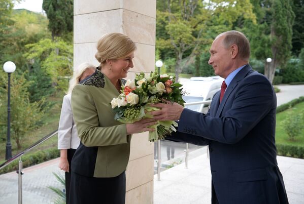 الرئيس الروسي فلاديمير بوتين يهدي باقة من الأزهار لرئيسة لرئيسة جمهورية كرواتيا كوليندا غرابر-كيتاروفيتش لدى وصولها إلى سوتشي، 2018 - سبوتنيك عربي